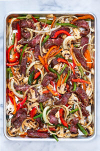 sheet pan of mixed ingredients to make philly cheesesteak bowls