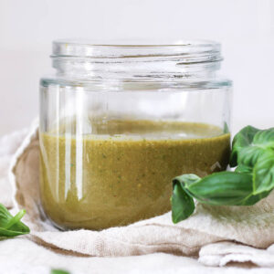 basil balsamic dressing in a glass jar on a linen napkin