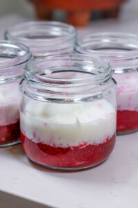 mashed raspberries, yogurt, and milk in a jar to make raspberry overnight oats
