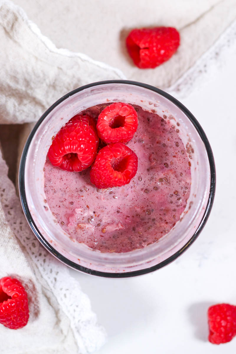 raspberry overnight oats in a glass jar with fresh raspberries