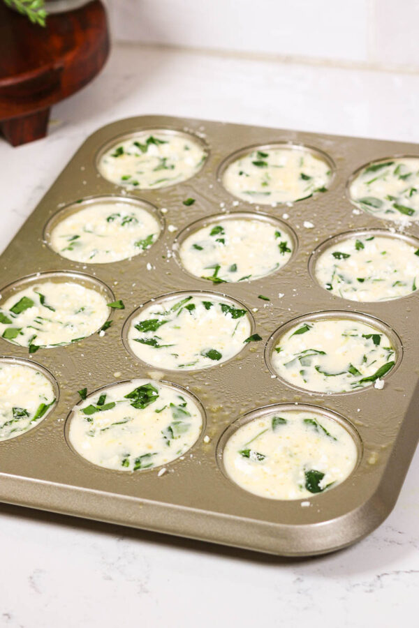 slightly poked down the spinach and feta toppings to mix a bit into the egg for spinach feta egg muffins