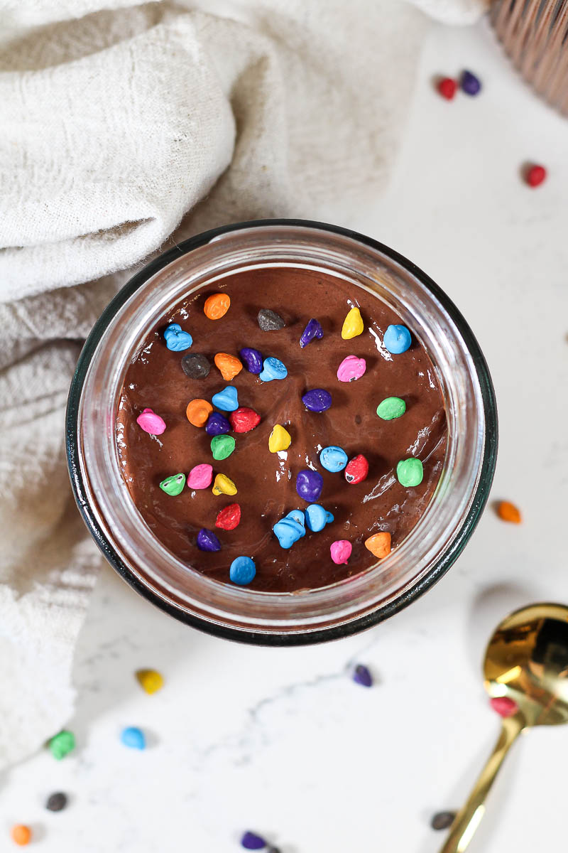 cosmic brownie overnight oats with rainbow chip sprinkles in a glass jar