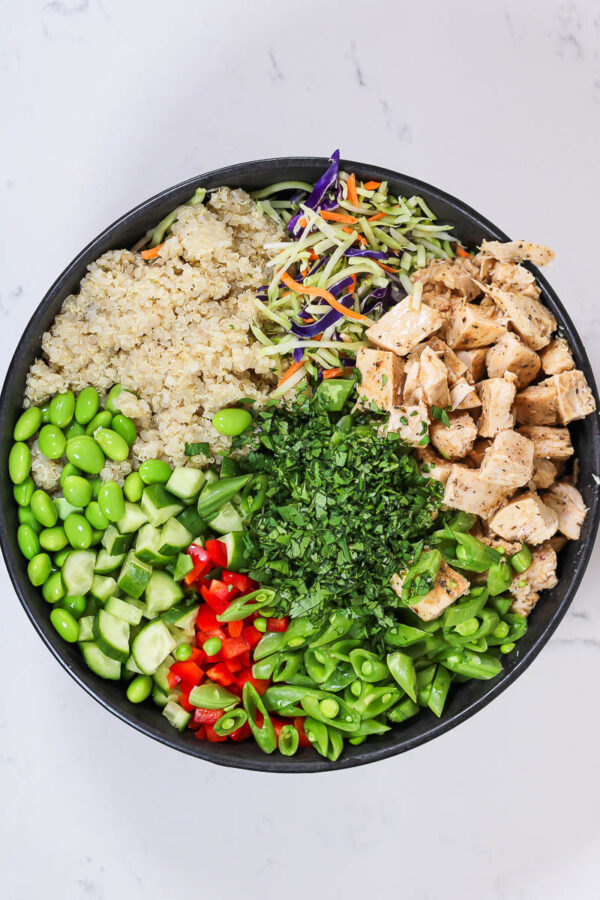 ingredients to make edamame quinoa salad in a large bowl - before adding dressing or tossing
