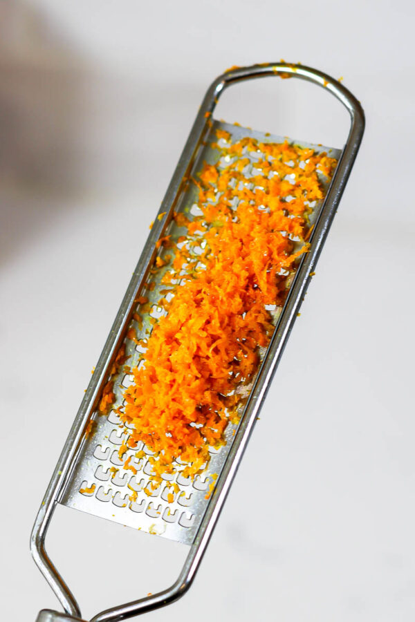 grating orange zest to make orange chia pudding