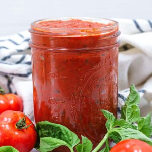 roasted tomato pasta sauce in a mason jar with fresh basil and fresh tomatoes