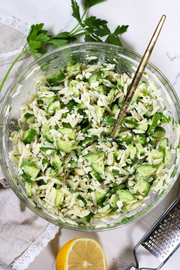 cucumber orzo salad in a glass bowl