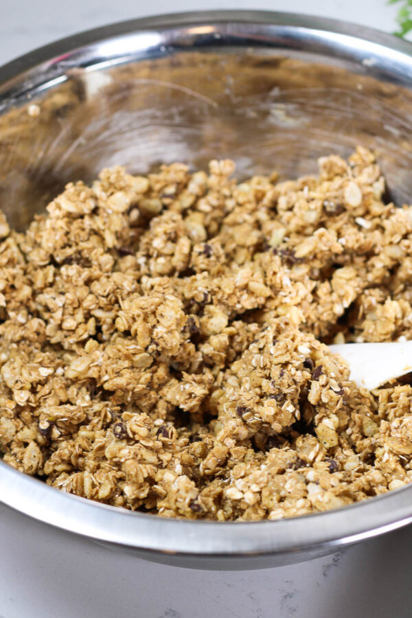 mixing ingredients in a stainless bowl to make nut free granola bars