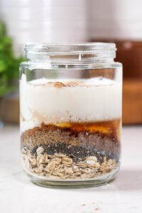 ingredients layered in a jar to make maple and brown sugar overnight oats