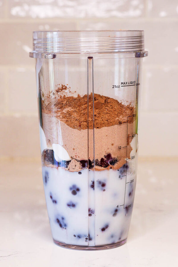 ingredients in a blender to make a chocolate blackberry smoothie