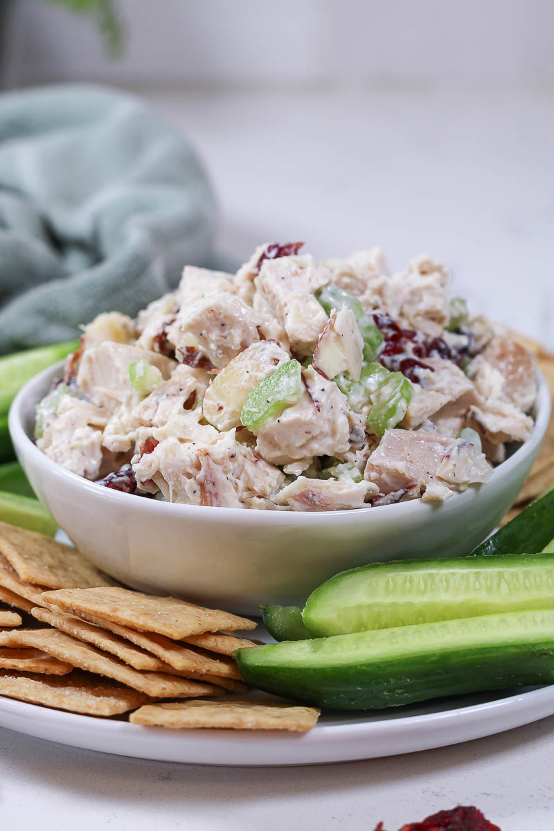 cranberry chicken salad with celery and almonds in a white bowl