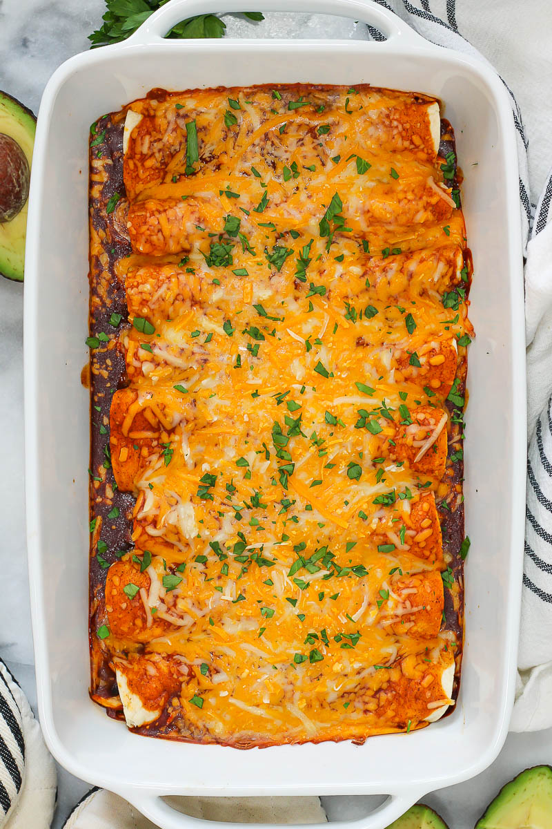 black bean and chicken enchiladas in a baking pan