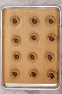 sheet pan of peanut butter cup cookies with reese's mini christmas trees placed in