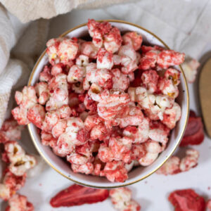 strawberry popcorn in a white and gold bowl