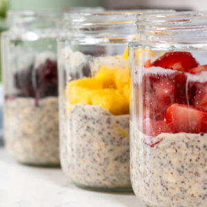jars of high protein overnight oats with frozen fruit