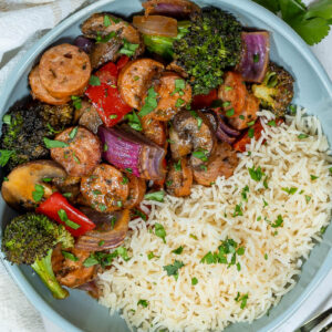 a bowl of sheet pan chicken sausage and veggies with rice