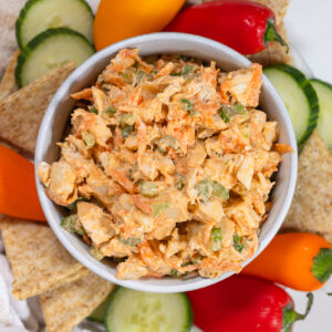 buffalo chicken salad on a platter with crackers and veggies