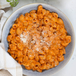 a bowl of roasted red pepper pasta topped with parmesan
