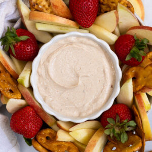 peanut butter yogurt dip with apple slices, strawberries, and pretzel crisps for dipping