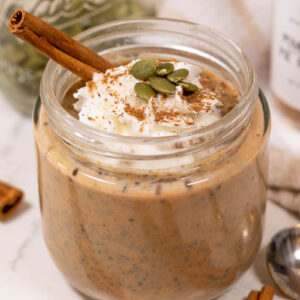pumpkin chia pudding topped with whipped cream and pumpkin seeds